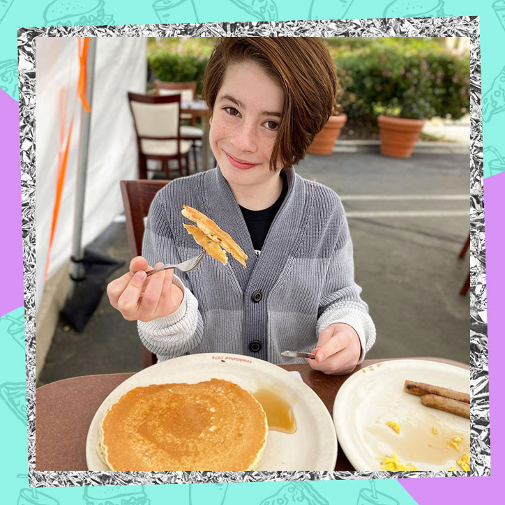 Actor Paxton Booth eating a plate of pancakes