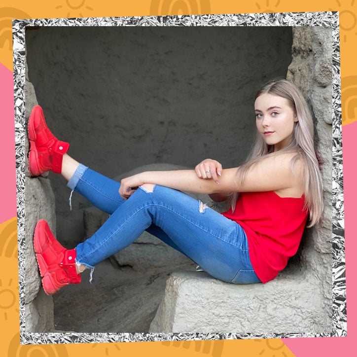 Mila Nabours sits on a stone bench with her legs up on a stone wall
