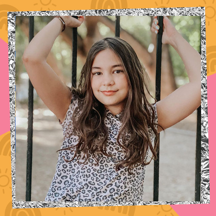 Reese Herron poses in front of a gate in a leopard print shirt