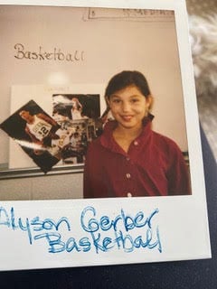 Author Alyson Gerber as a kid, standing in front of her elementary school report about basketball
