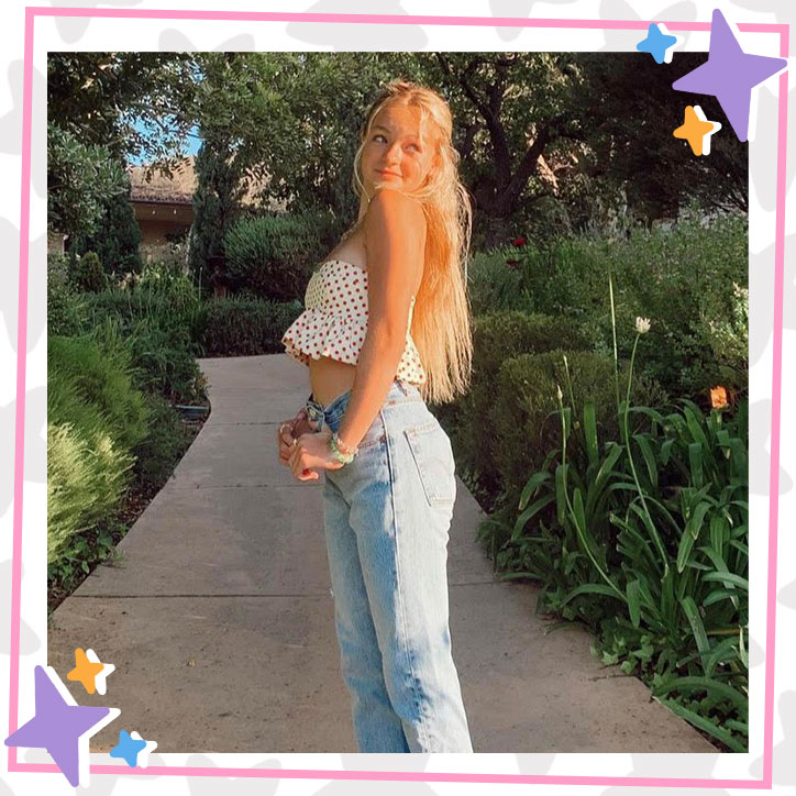 Pressley Hosbach poses with her hair pulled back in a polkadot crop top and jeans