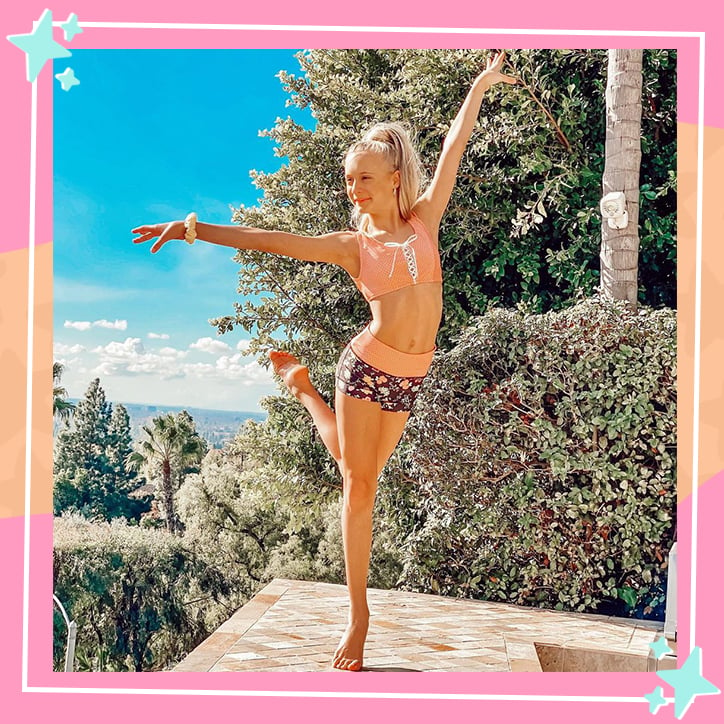 Dancer Katie Couch poses with her arms in the air, balanced on one leg