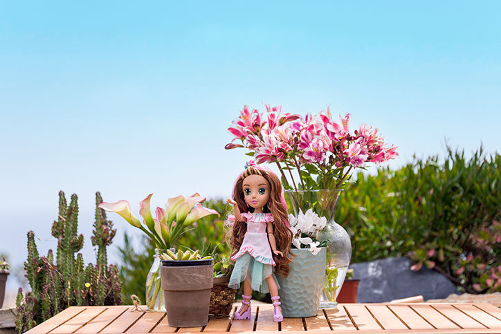 Ivy from the B-Kind Dolls poses in front of a desert backdrop and pretty plants