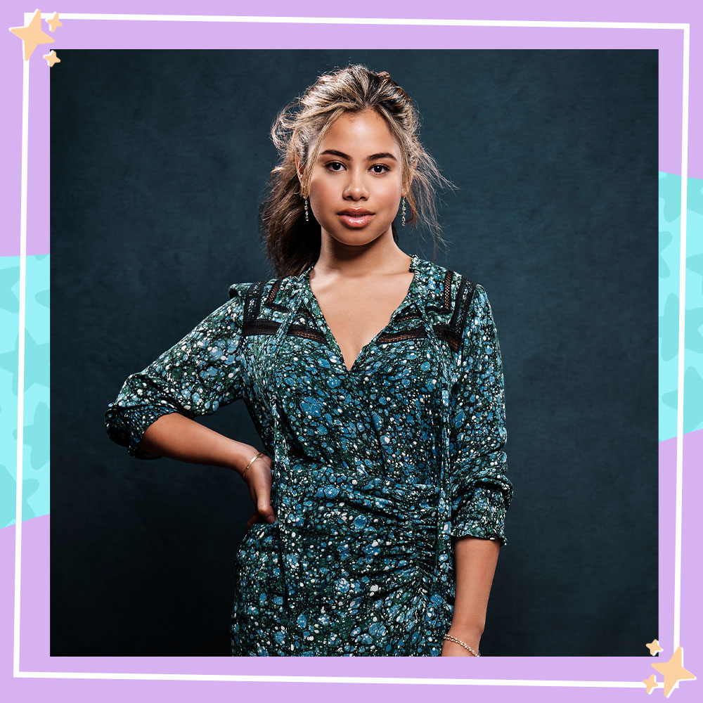 Tess Romero poses in a sparkly teal dress with her hand on her hip and her hair in a low ponytail