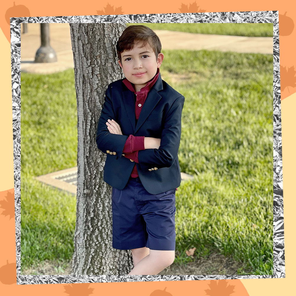 Miguel Gabriel poses in front of a tree wearing his school uniform