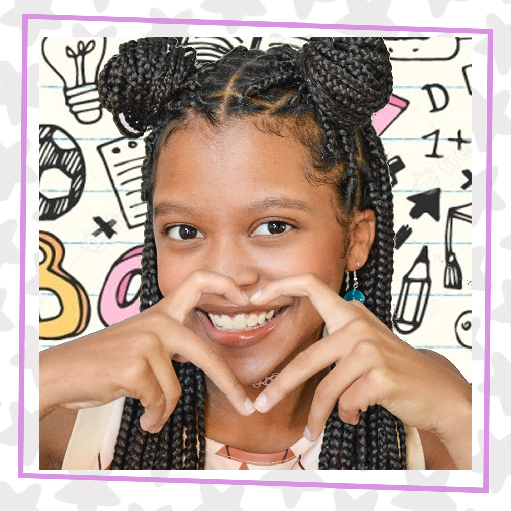 Nadia Simms makes a heart with her hands, her braided hair is up in space buns