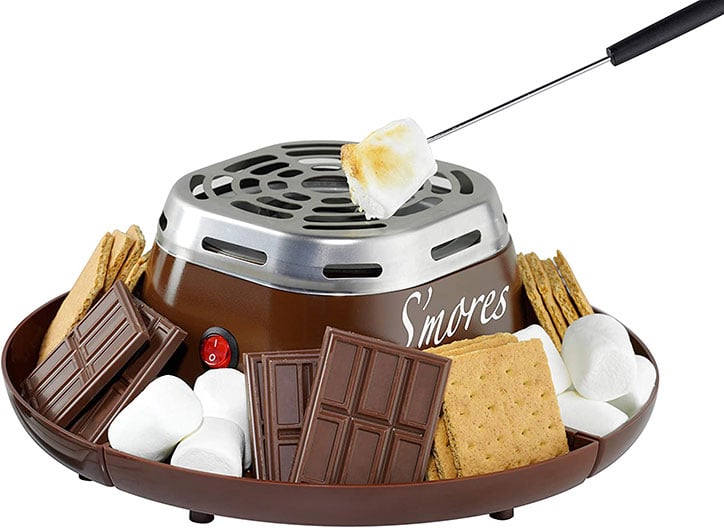 Stock photo of an at-home smores making kit with room to hold graham crackers, marshmallows, and chocolate along the sides and a burner for roasting in the middle