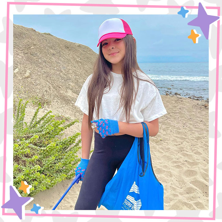 Brielle Lopez stands on a California beach where she is picking up trash.