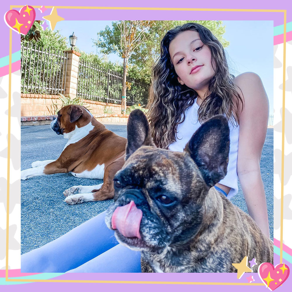 Hayley LeBlanc sitting outside with her dogs.