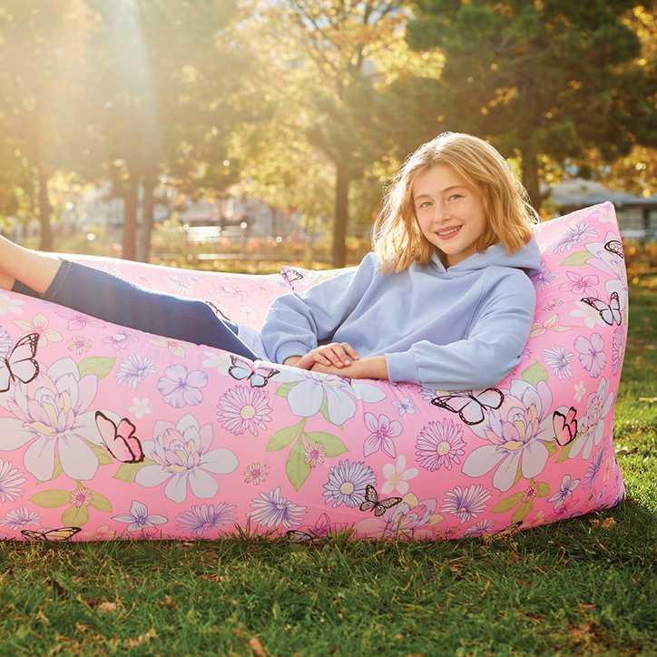 Lifestyle photo of a tween girl in a backyard sitting in the 3C4G Butterfly Inflatable Lounge chair