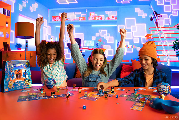 Lifestyle photo of three kids sitting at a table playing Disney Kingdomania