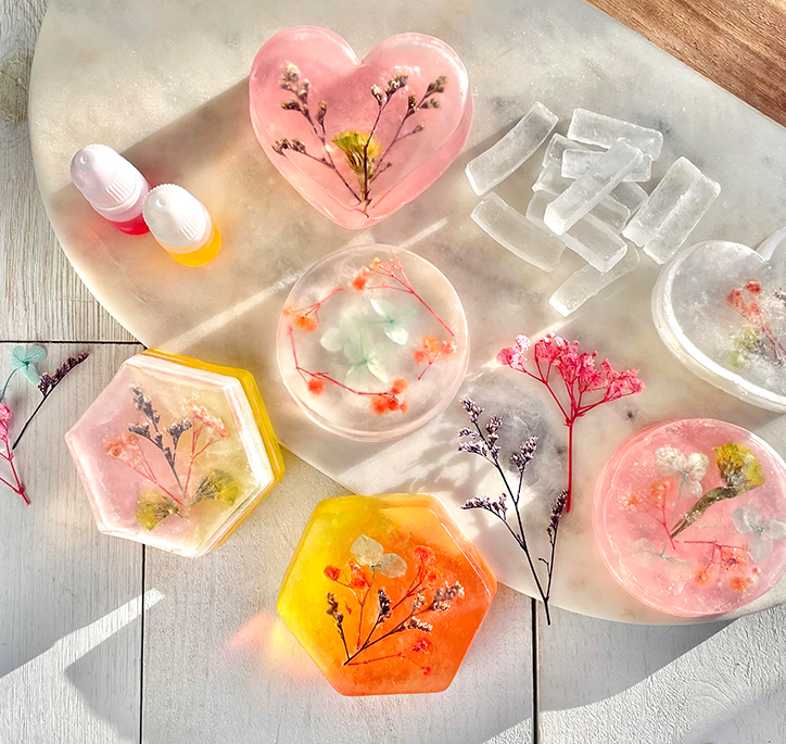 Lifestyle photo of some of the completed soaps from the Wish*Craft Flower Power DIY Soaps kit with dried flowers pressed into each one
