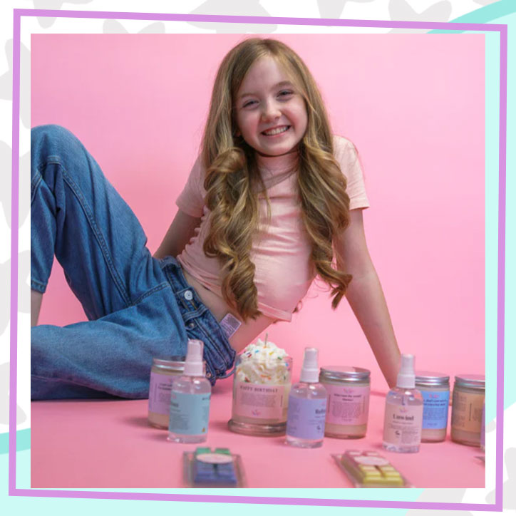 Lily of Lily Lou's Aromas posing with some of the products in her candle and wax melt lines