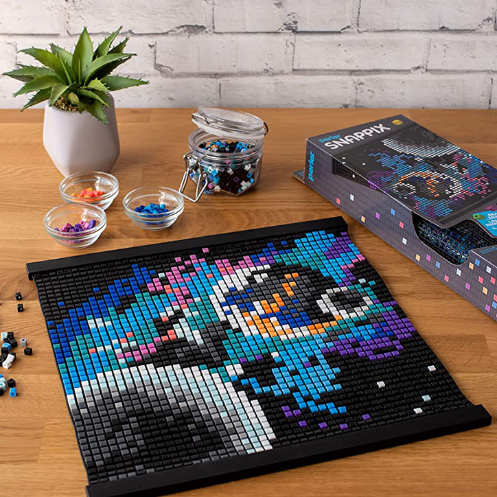 A fully completed Perler Snappix Celestial kit laid out on a wooden table.