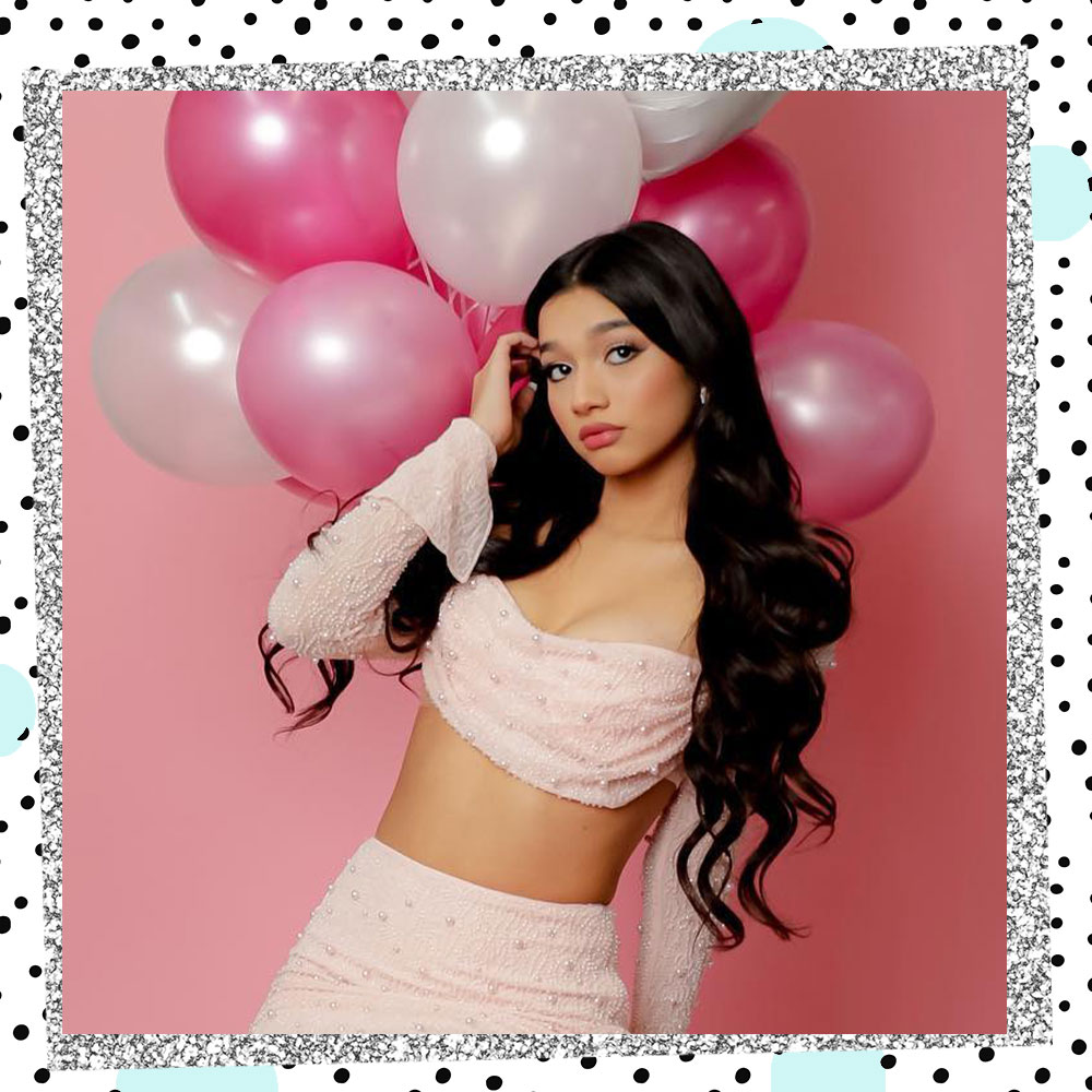 Jasmine Mir poses in front of pink and white balloons for her 15th birthday
