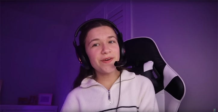 Cilla from JKrew Gaming wearing a headset, sitting in a black and white gaming chair