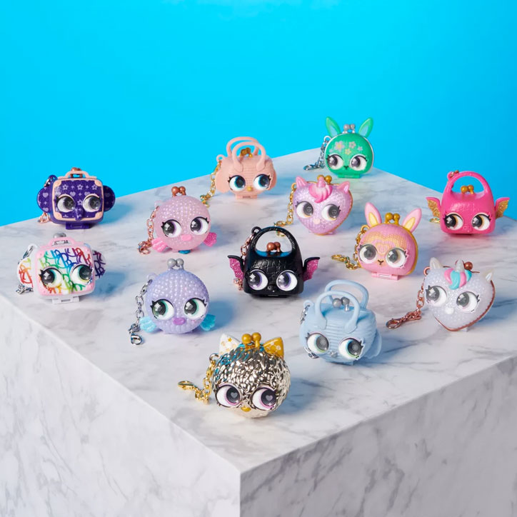 Full collection of 13 Purse Pets Luxey Charms laid out on a marble table