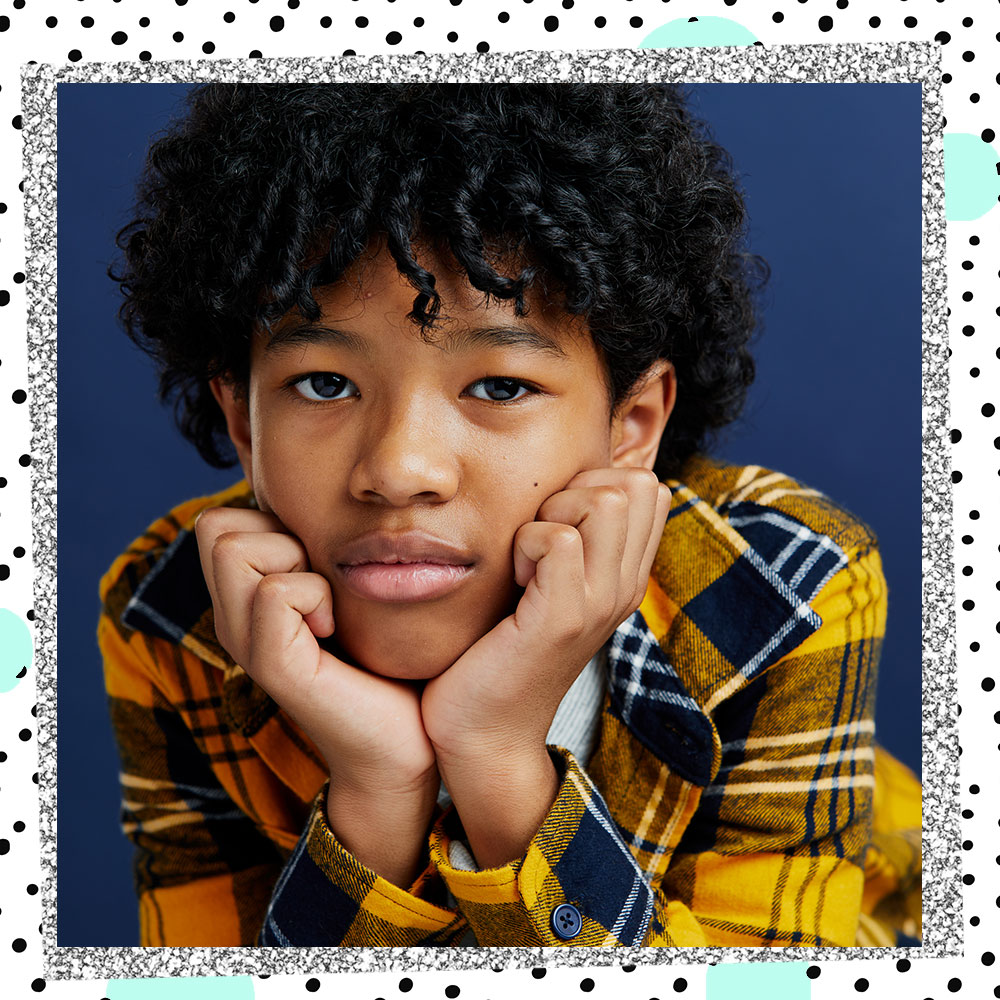 Closeup of Jakari Fraser in a yellow flannel, resting his chin in his hands