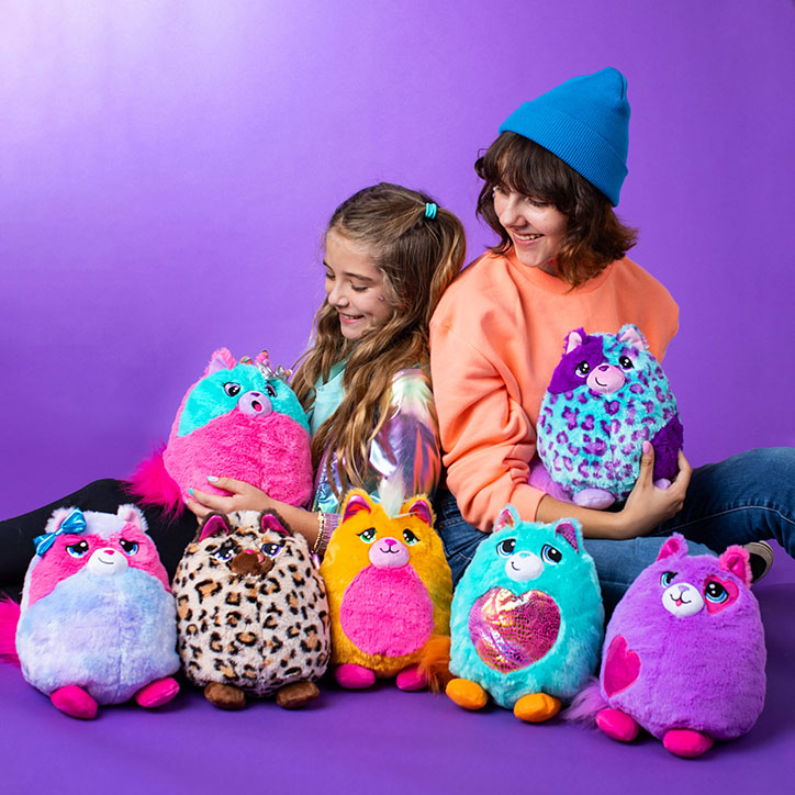 Two tween girls sitting together surrounded by Misfittens plush cats