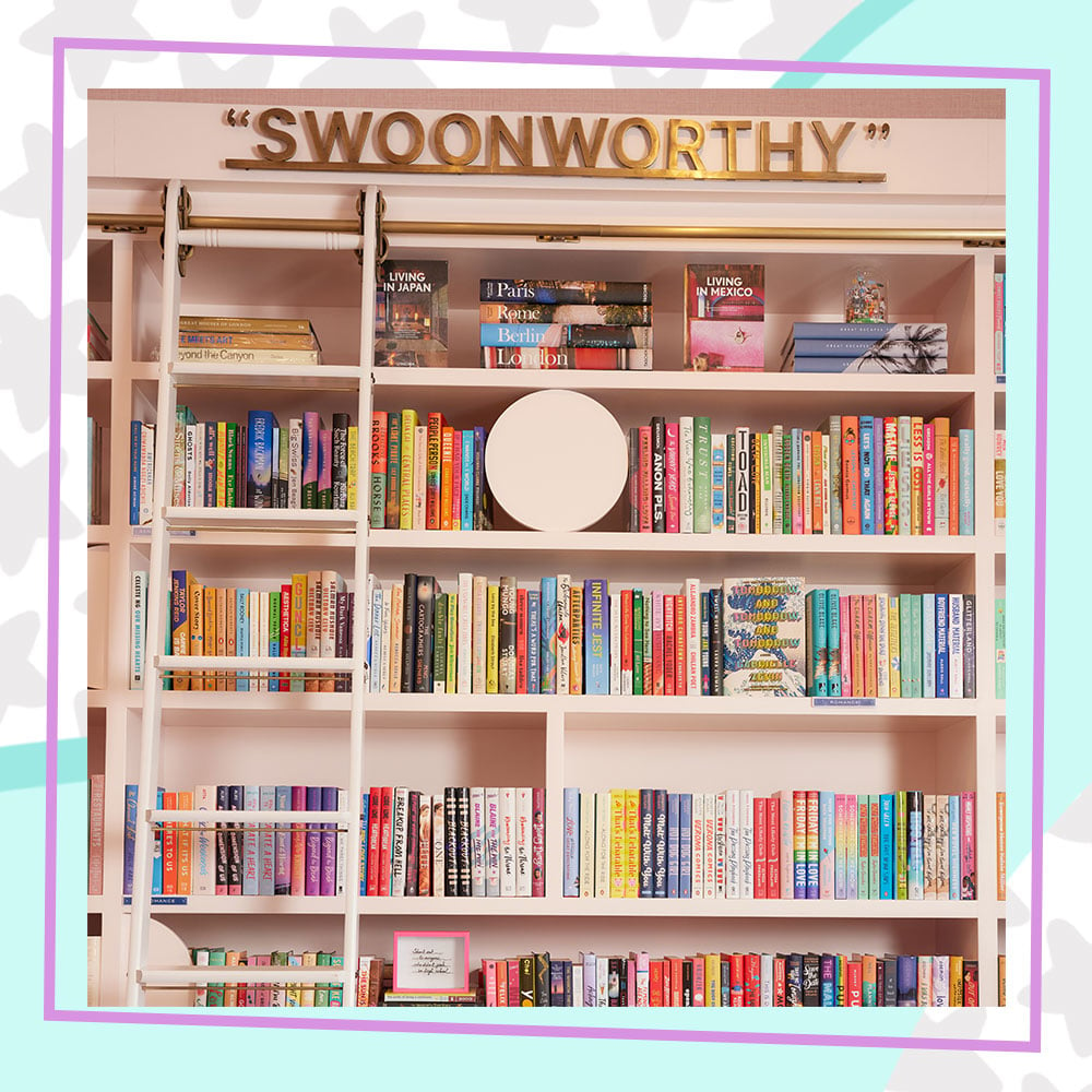 A wall of YA books inside Annabelle's Book Club LA. There are five shelves filled with colorful book covers and a sign hangs above that says "Swoonworthy"