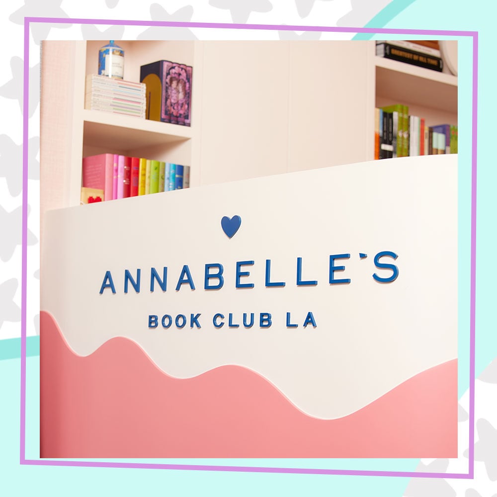 The counter at Annabelle's Book Club LA. It is white with a light pink wave painted across it, with the store logo in blue.
