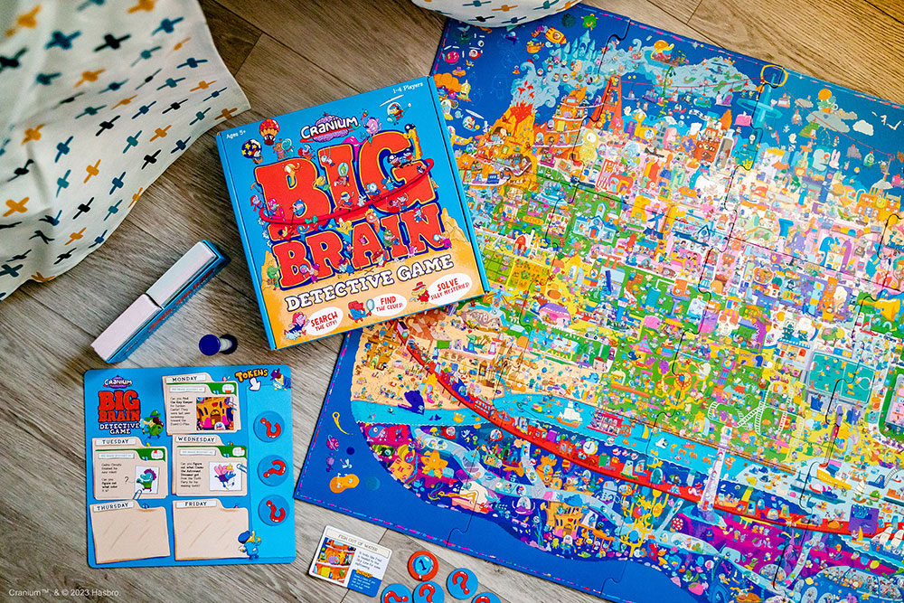 Cranium Big Brain Detective Game puzzle map, game box, and other game pieces laid out on a wooden table