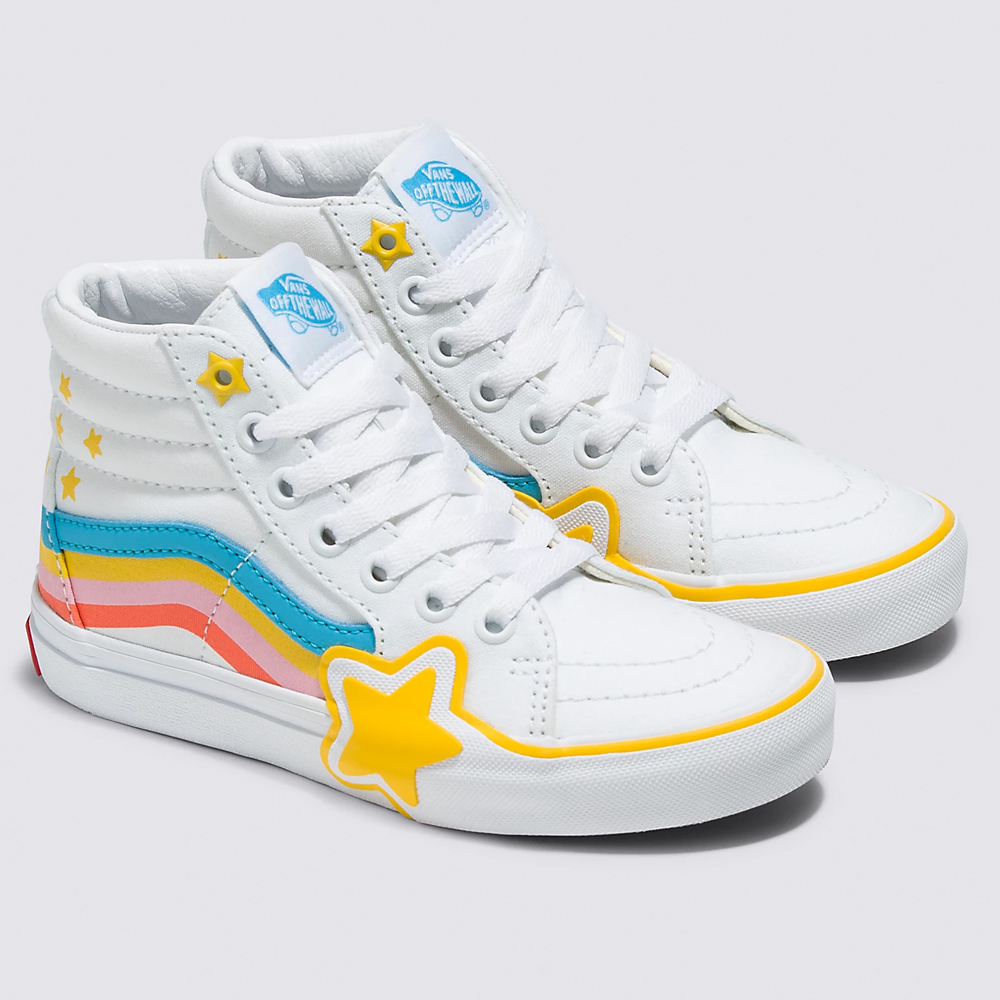 A pair of white hi-top Vans sneakers with white shoelaces. There is a shooting star across the side of the sneaker and small yellow stars randomly placed around the back side.