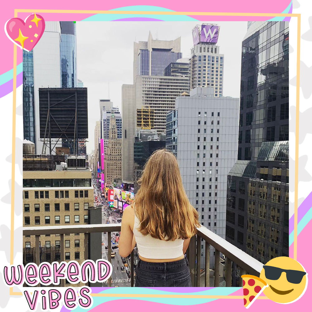 Paige Stein stands on a rooftop in NYC looking out over the city skyline