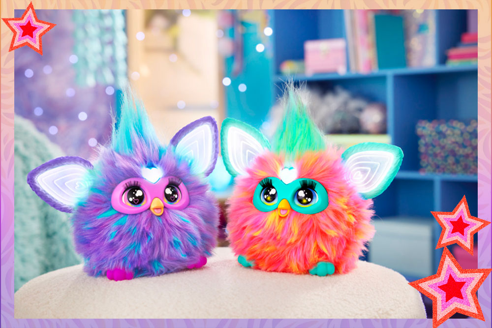 Purple and Coral Furbys sitting next to each other on an ottoman in a cute tween bedroom