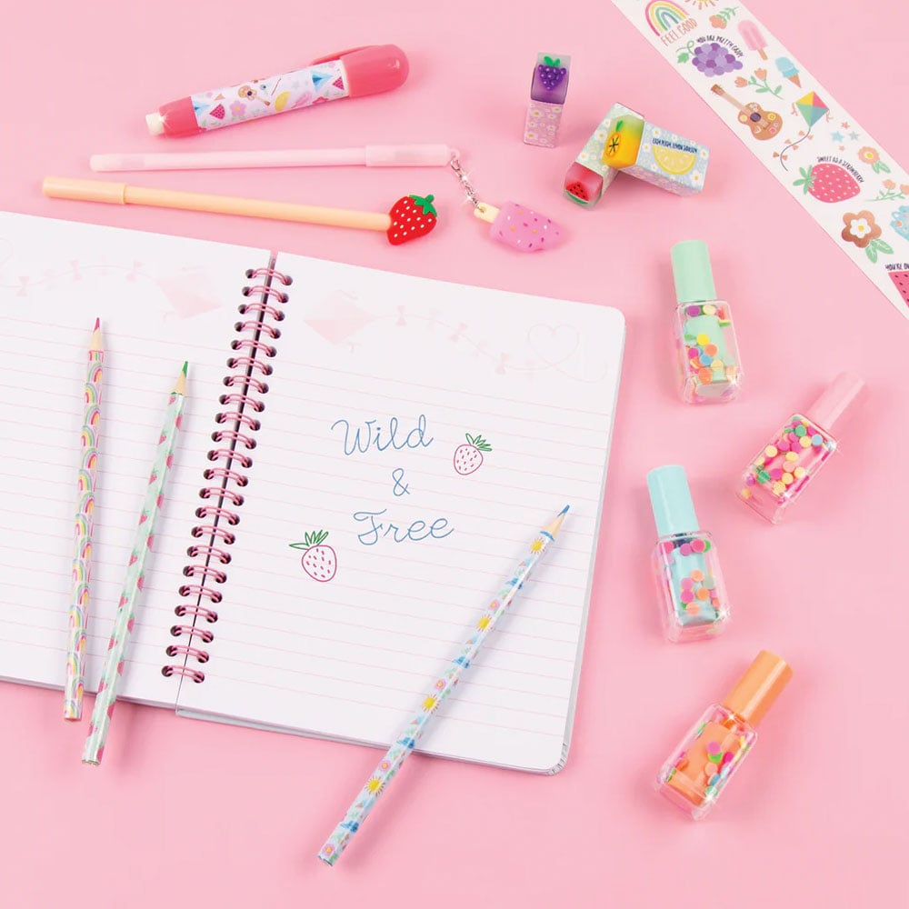 Flat lay of the items in the Adventure Fun Stationery Set including a journal, patterned pencils, a sticker sheet, nail polish bottles, and more