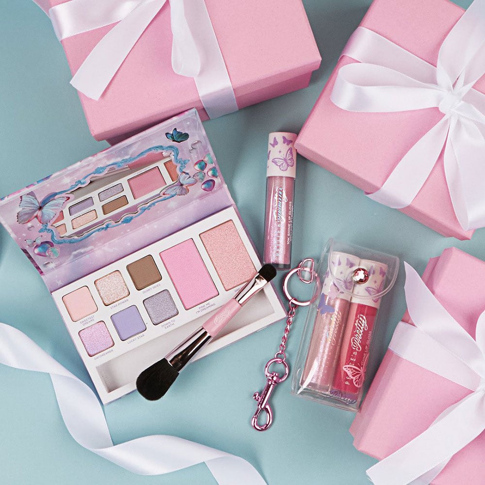 Dream Land Makeup Starter Set AND So Dreamy 10K Shine Lip Gloss Duo laid out on a table surrounded by ribbons and gifts