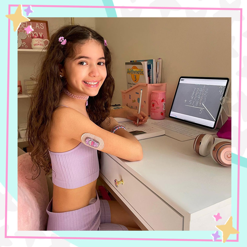 Bella Mir sitting at her desk, laptop open, ready for her school day.