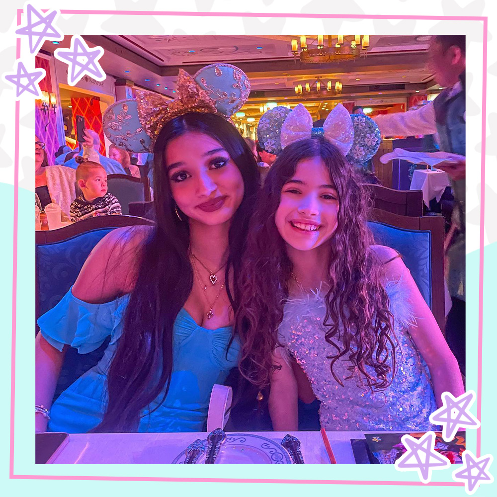 Jasmine and Bella Mir wearing Mickey ears at a Disney restaurant
