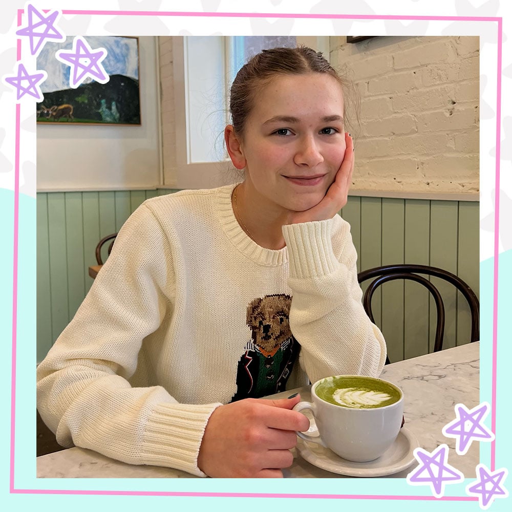 Cilla sitting in a coffeeshop drinking a matcha